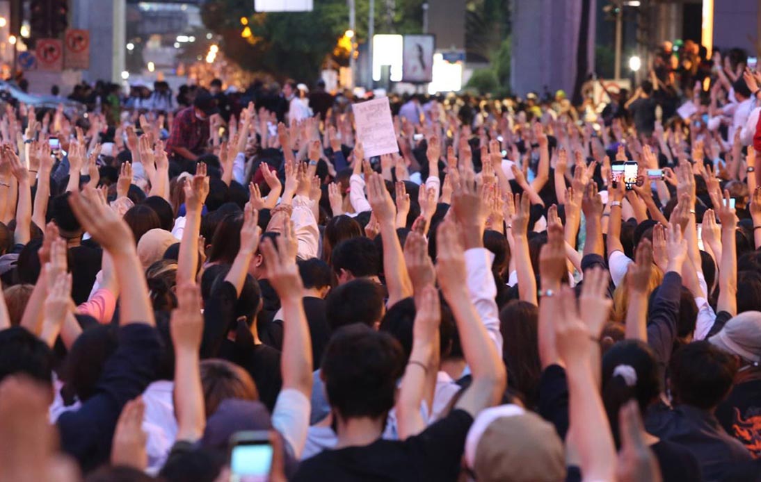 Thai protesters with their hand sign